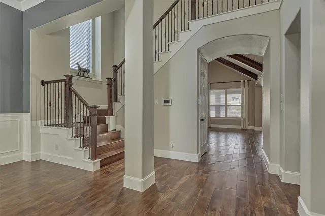a view of front door with hallway and wooden floor