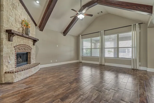 a view of an empty room with glass door and chandelier fan