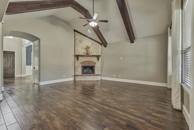 a view of an empty room with a fireplace and a window