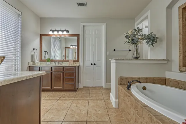 a bathroom with a bathtub sink and mirror