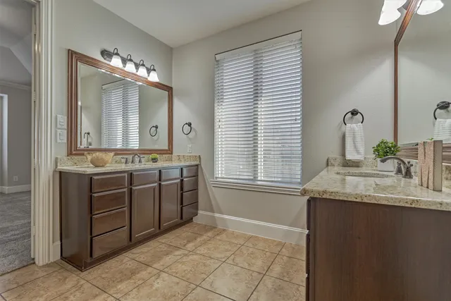 a bathroom with a granite countertop sink a mirror and a vanity