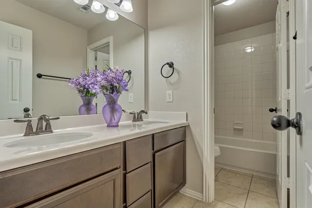 a bathroom with a granite countertop sink a mirror and a shower