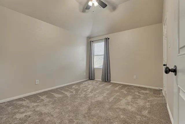 an empty room with chandelier fan
