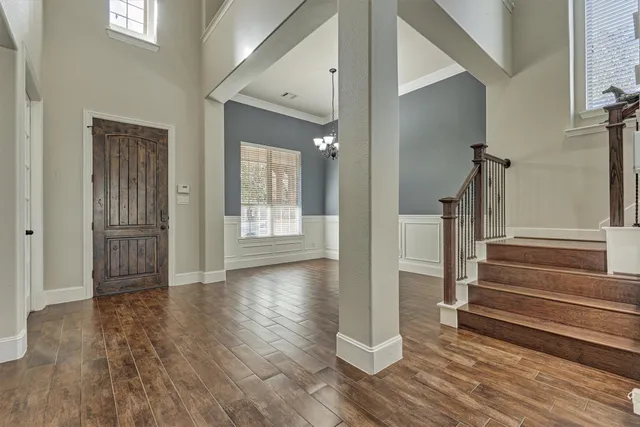 a view of a hallway with wooden floor and staircase