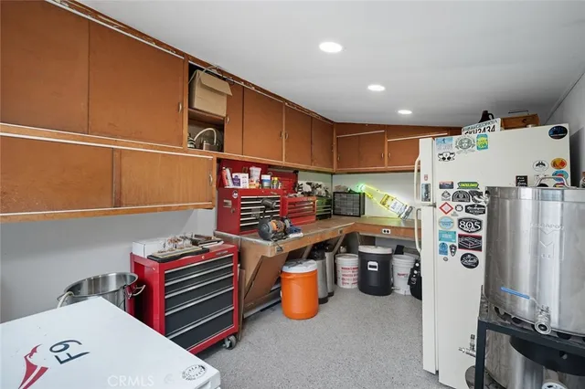 a storage room with stainless steel appliances wooden floor and a window