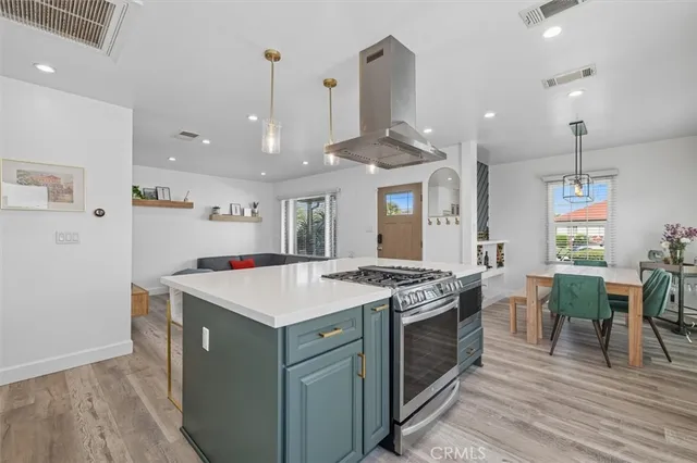 a kitchen that has a lot of cabinets a sink and wooden floor