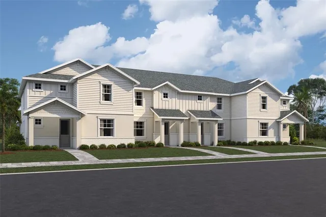 a view of a white house with a big yard and large trees