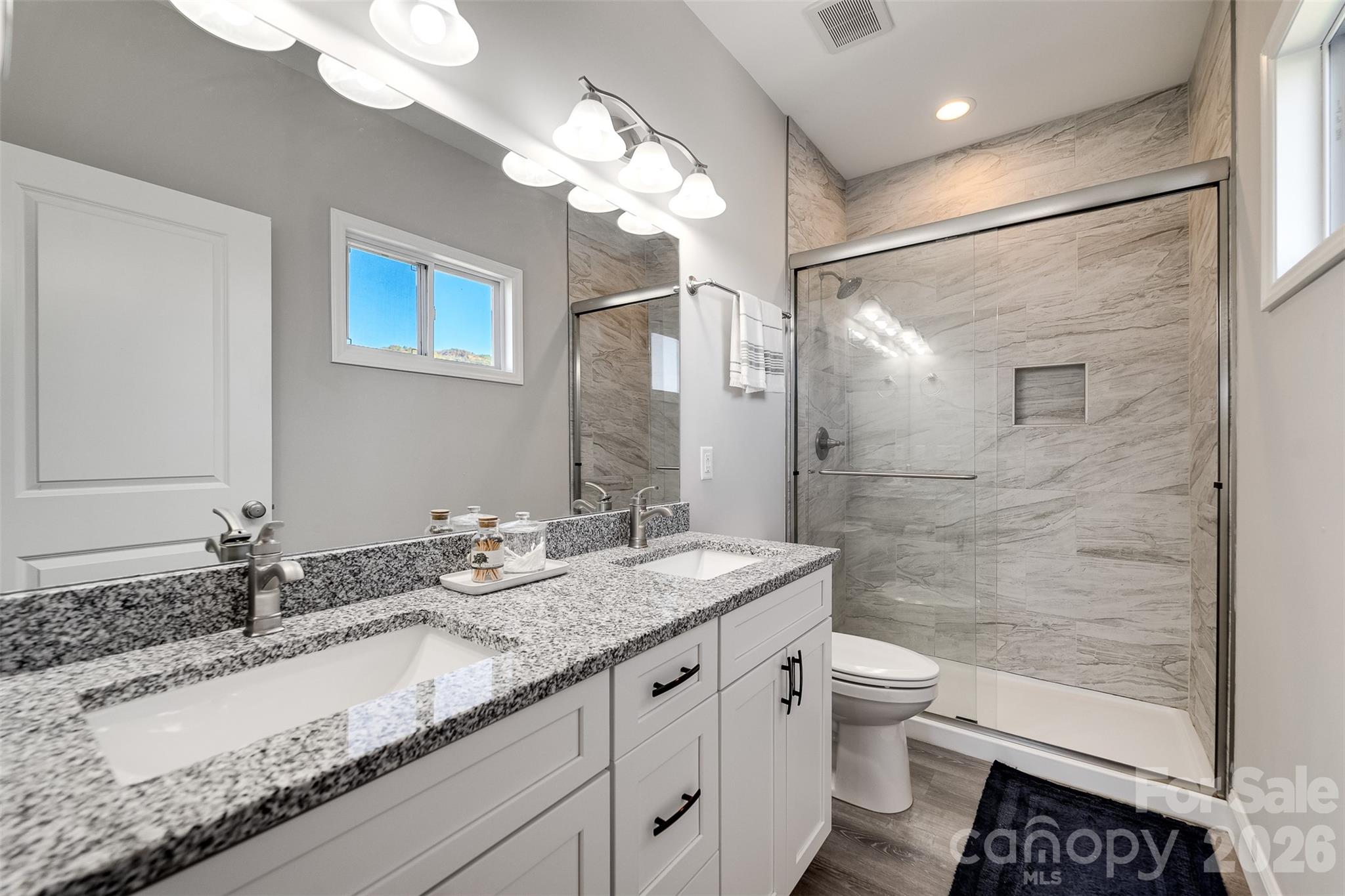 955 North Canton Road Canton, NC 28716 - Photo 15 of 48 a bathroom with a granite countertop sink a toilet a mirror and shower