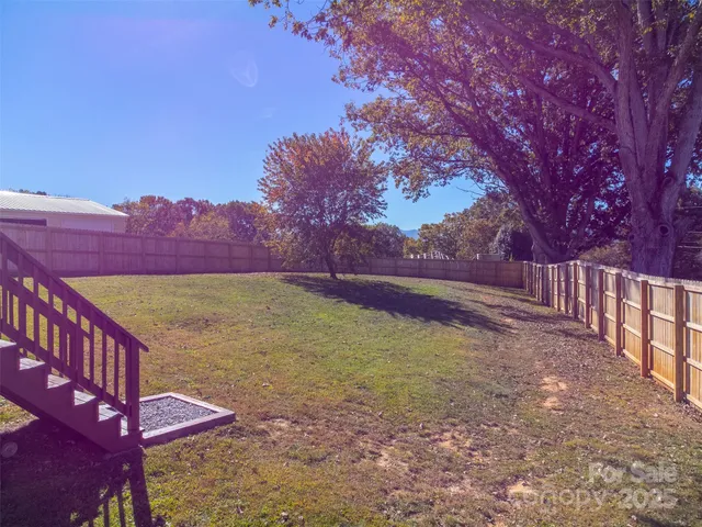 a view of a yard with wooden fence