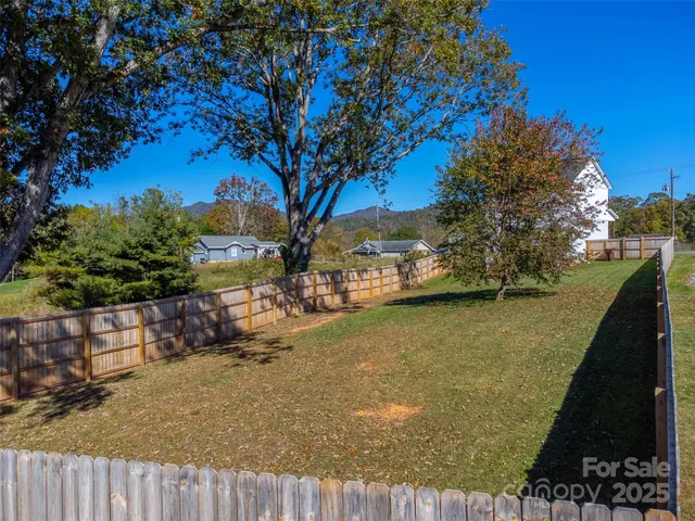 a view of a yard with wooden fence