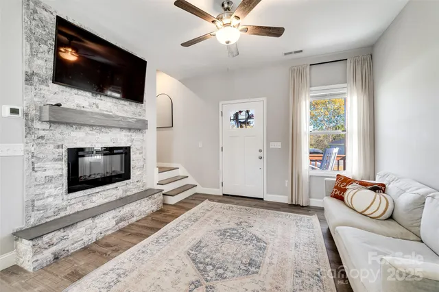 a living room with furniture a flat screen tv and a fireplace