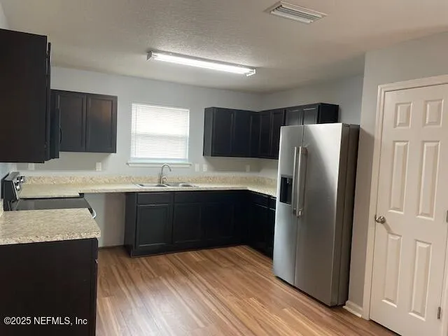 a kitchen with granite countertop a refrigerator and a sink