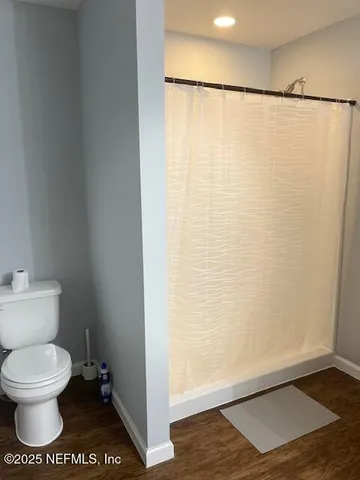 a bathroom with a toilet and a shower