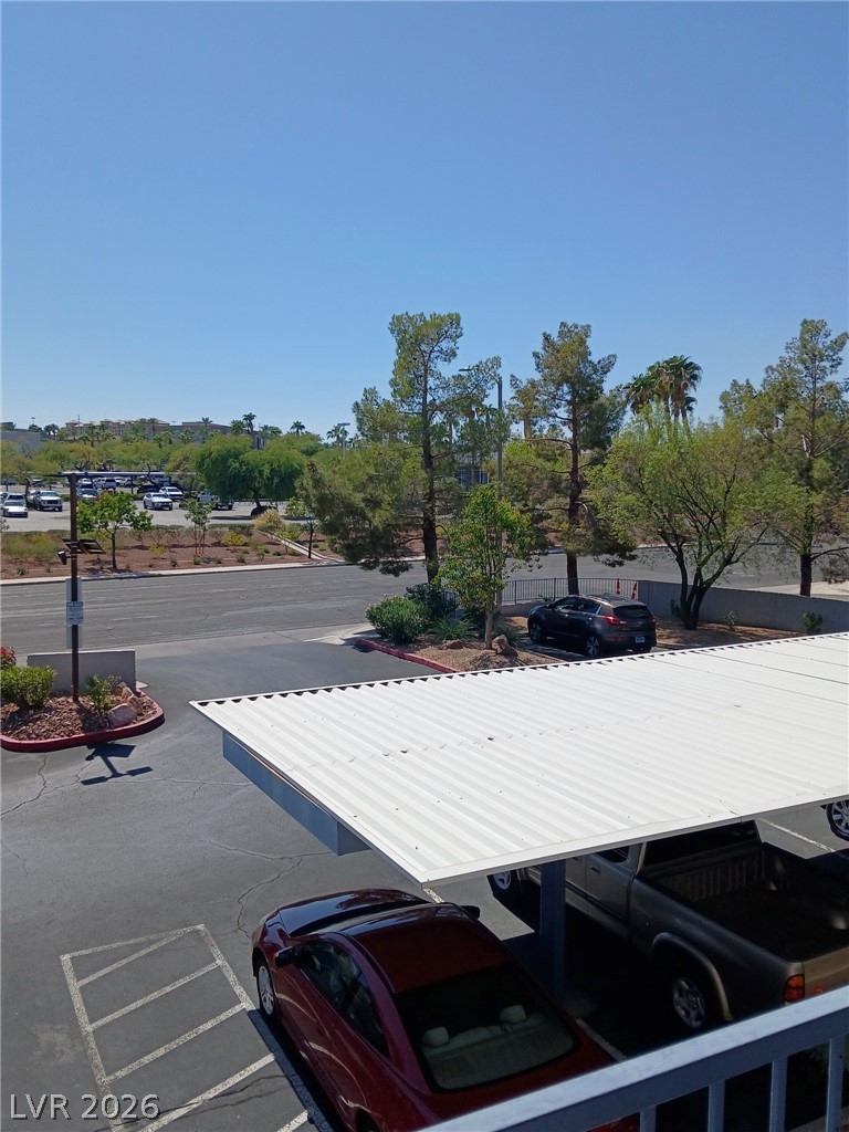 2201 Ramsgate Drive, Unit 426 Henderson, NV 89074 - Photo 6 of 22 This outdoor view showcases ample parking with covered options, surrounded by lush landscaping.