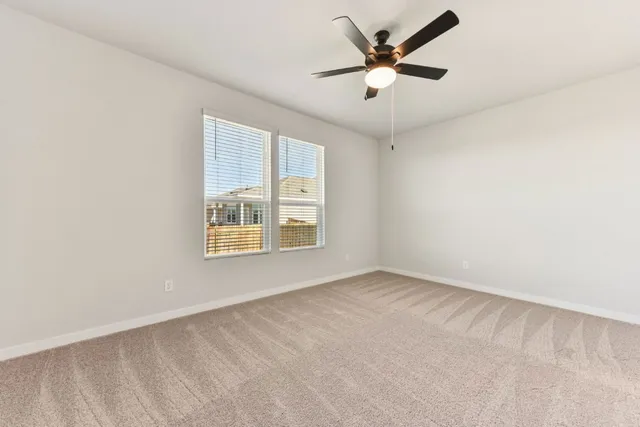 an empty room with a window and a ceiling fan