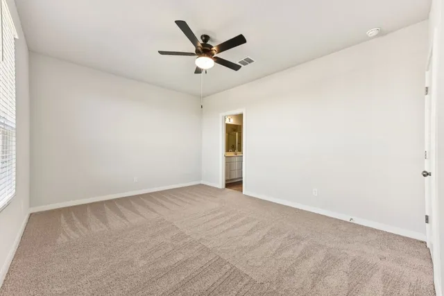 an empty room with closet and ceiling fan