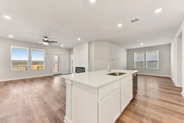 a large white kitchen with sink and refrigerator