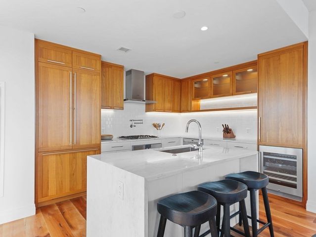 a kitchen with stainless steel appliances granite countertop a sink cabinets and wooden floor