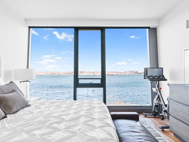 a bedroom with a bed and large windows