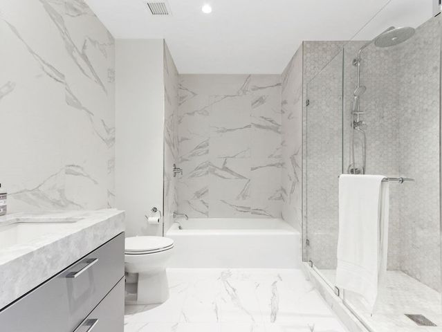 a bathroom with a sink a toilet and shower