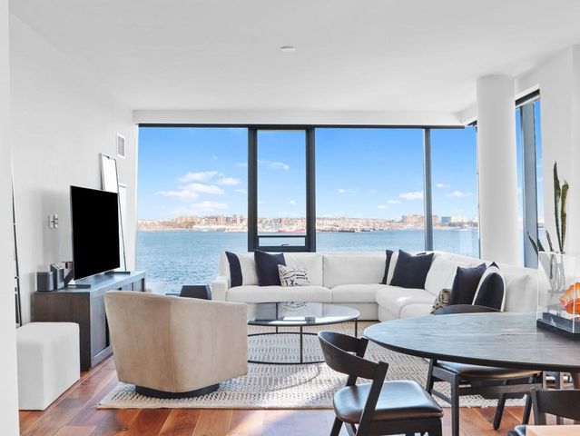 a living room with couches a coffee table and a flat screen tv