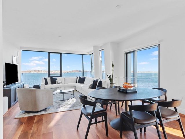 a living room with furniture a flat screen tv and a large window
