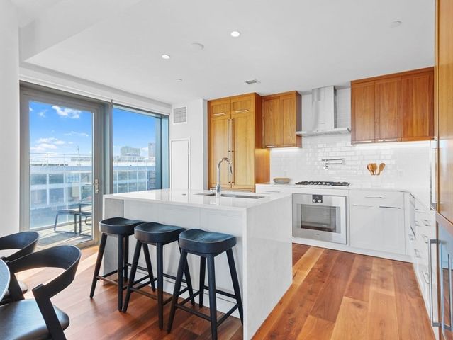 a kitchen with stainless steel appliances granite countertop a stove a sink and a refrigerator