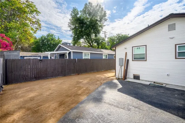 a view of a house with a backyard and a large tree