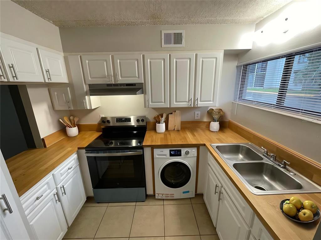 1108 Bartow Road, Unit 107 Lakeland, FL 33801 - Photo 3 of 12 a kitchen with a stove sink and refrigerator