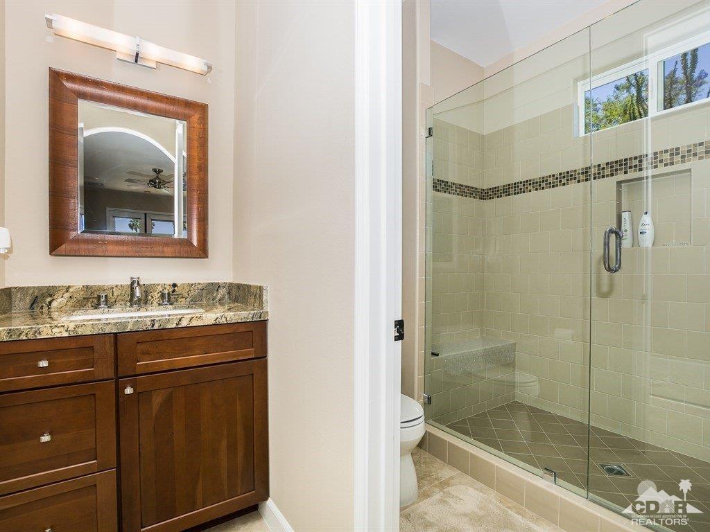 285 Loch Lomond Road Rancho Mirage, CA 92270 - Photo 30 of 48 a bathroom with a granite countertop sink mirror and shower