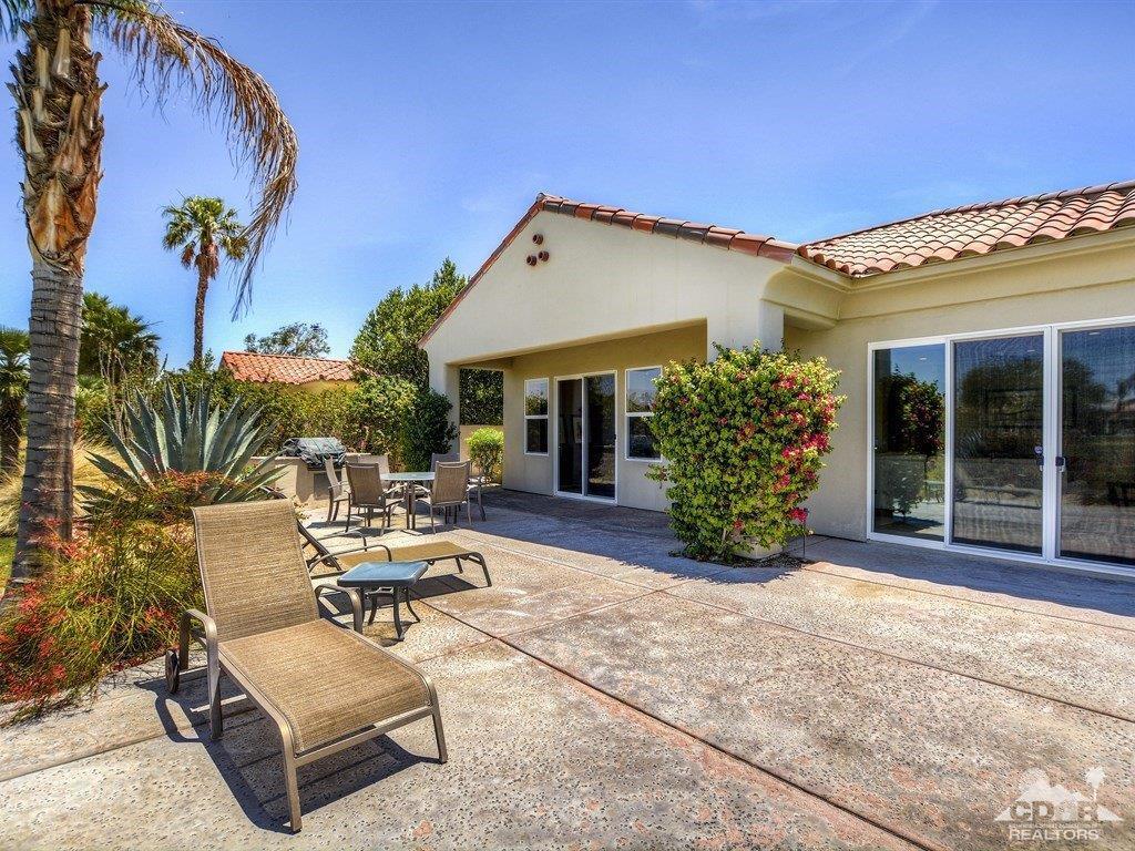 285 Loch Lomond Road Rancho Mirage, CA 92270 - Photo 38 of 48 a view of a patio with dining table and chairs under an umbrella