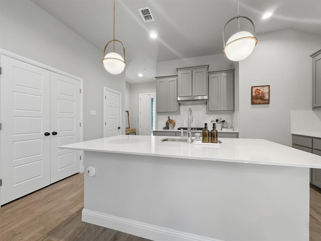 2216 Redwing Drive Denton, TX 76205 - Photo 11 of 38 a view of a kitchen with kitchen island a sink and wooden floor