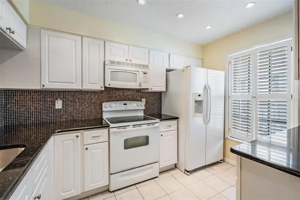 a kitchen with a stove a refrigerator and cabinets