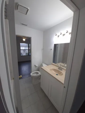a spacious bathroom with a toilet sink and mirror