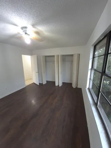 a view of empty room with wooden floor