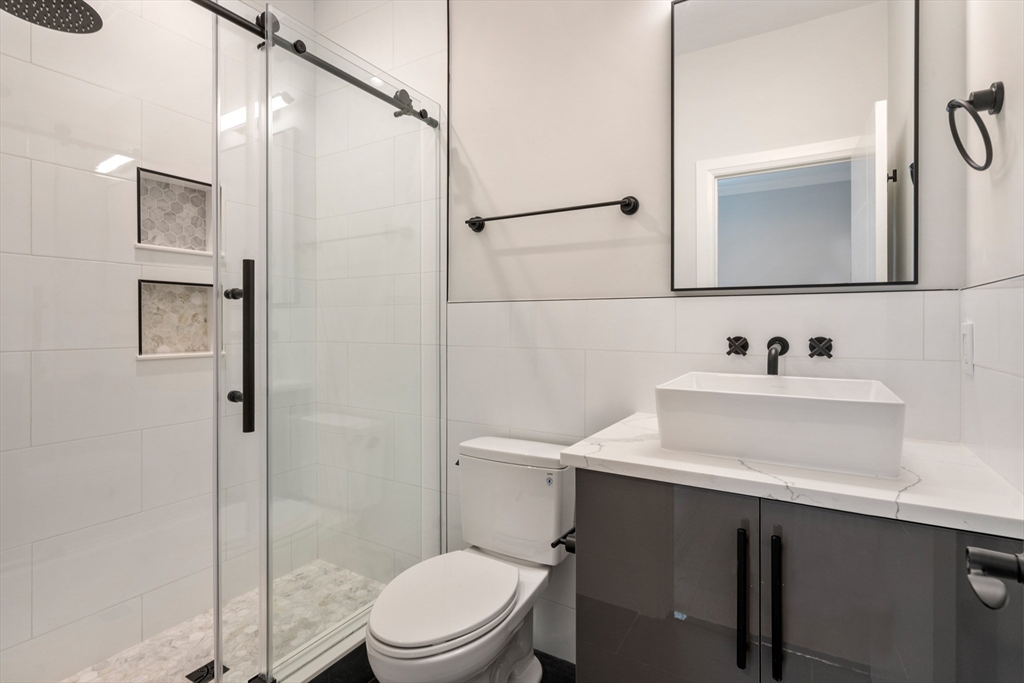 142 Pleasant Street Boston, MA 02125 - Photo 11 of 24 a bathroom with a sink toilet and shower