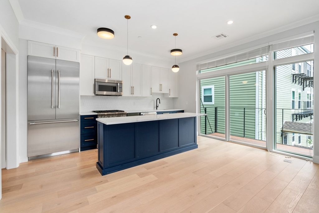 142 Pleasant Street Boston, MA 02125 - Photo 23 of 24 a large kitchen with a large window and stainless steel appliances