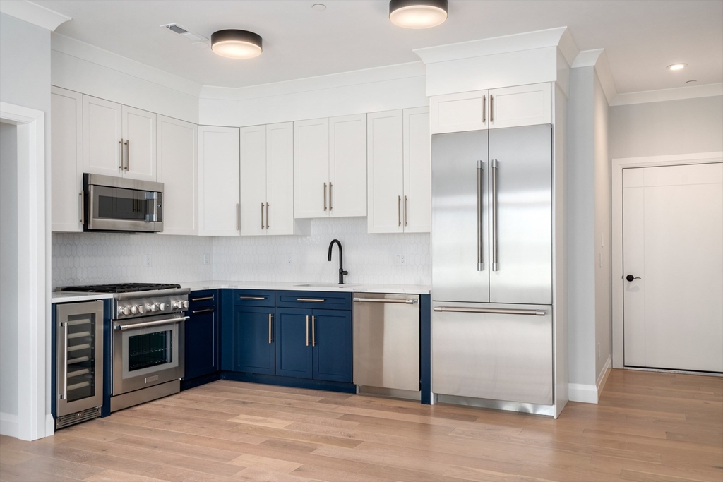 142 Pleasant Street Boston, MA 02125 - Photo 4 of 24 a kitchen with stainless steel appliances granite countertop a refrigerator and a stove top oven