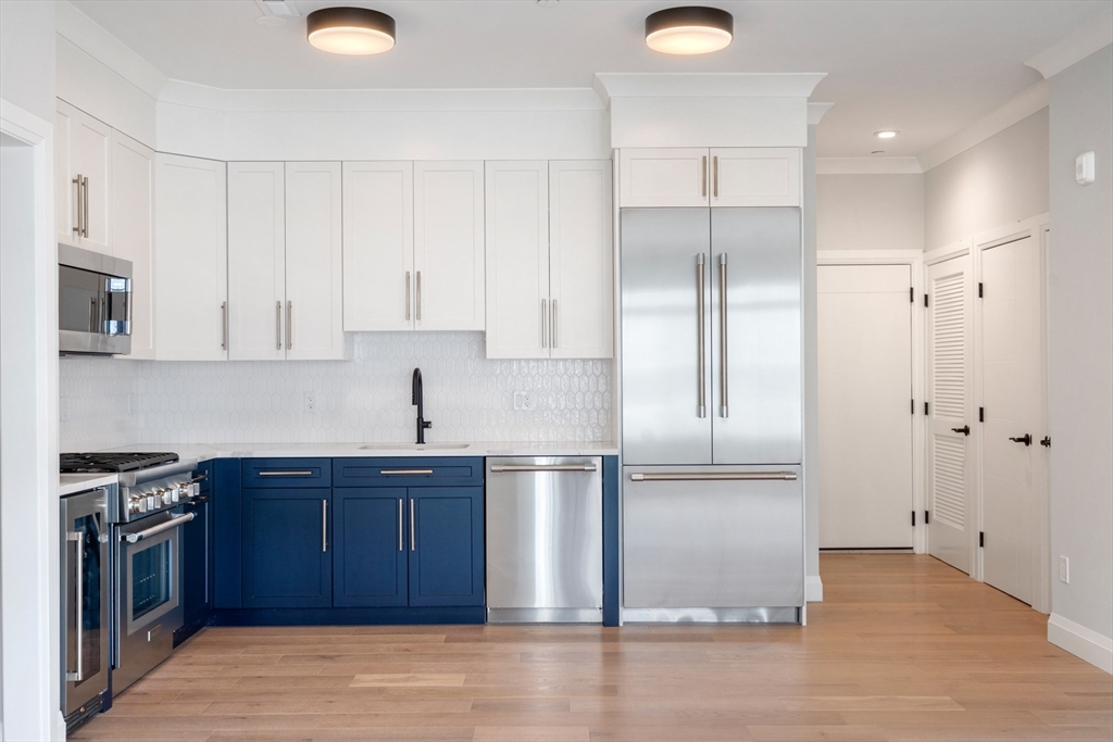 142 Pleasant Street Boston, MA 02125 - Photo 5 of 24 a kitchen with stainless steel appliances granite countertop a refrigerator and a sink
