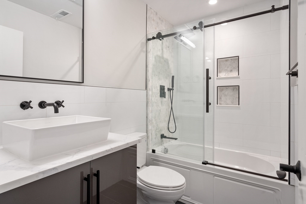 142 Pleasant Street Boston, MA 02125 - Photo 7 of 24 a bathroom with a sink toilet and shower