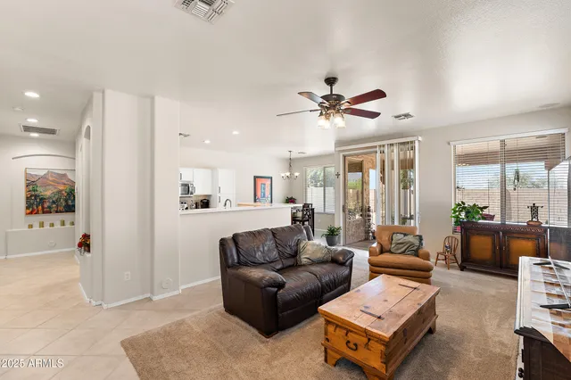 a living room with furniture and a ceiling fan
