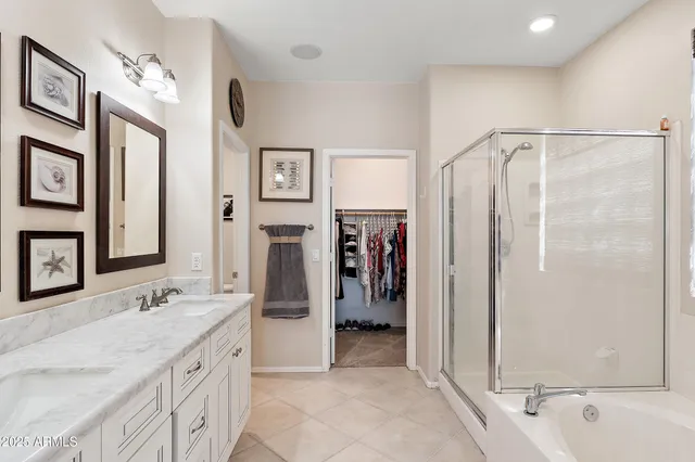a spacious bathroom with a granite countertop sink a mirror a shower and a bathtub