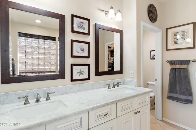 a bathroom with double vanity sinks a mirror and a window