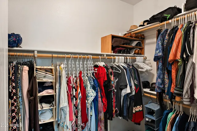 a view of walk in closet with clothes and shoes