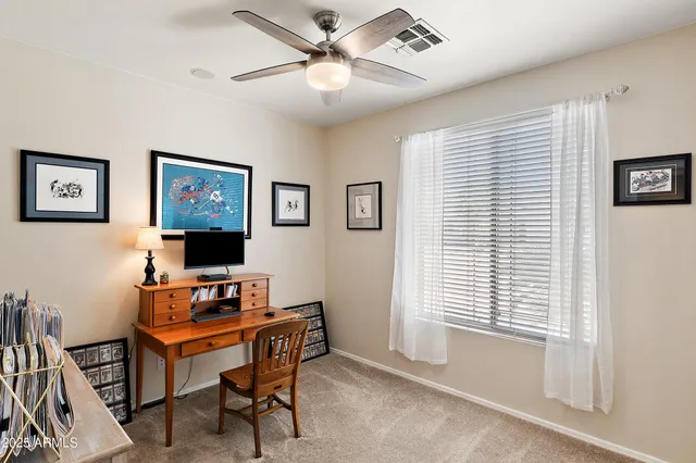a view of a workspace with furniture and a window