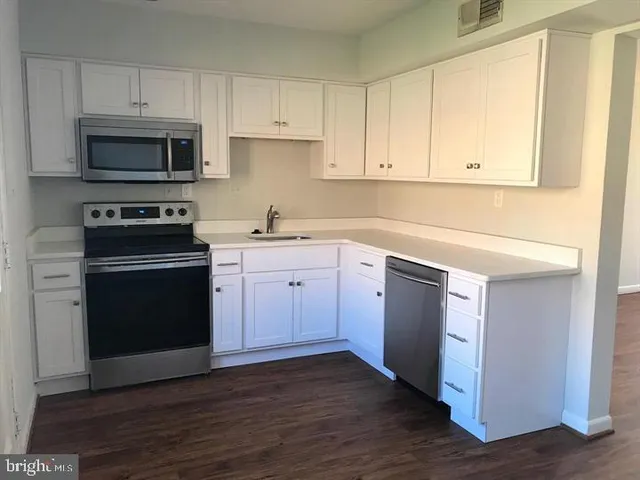 a kitchen with a sink stove and cabinets