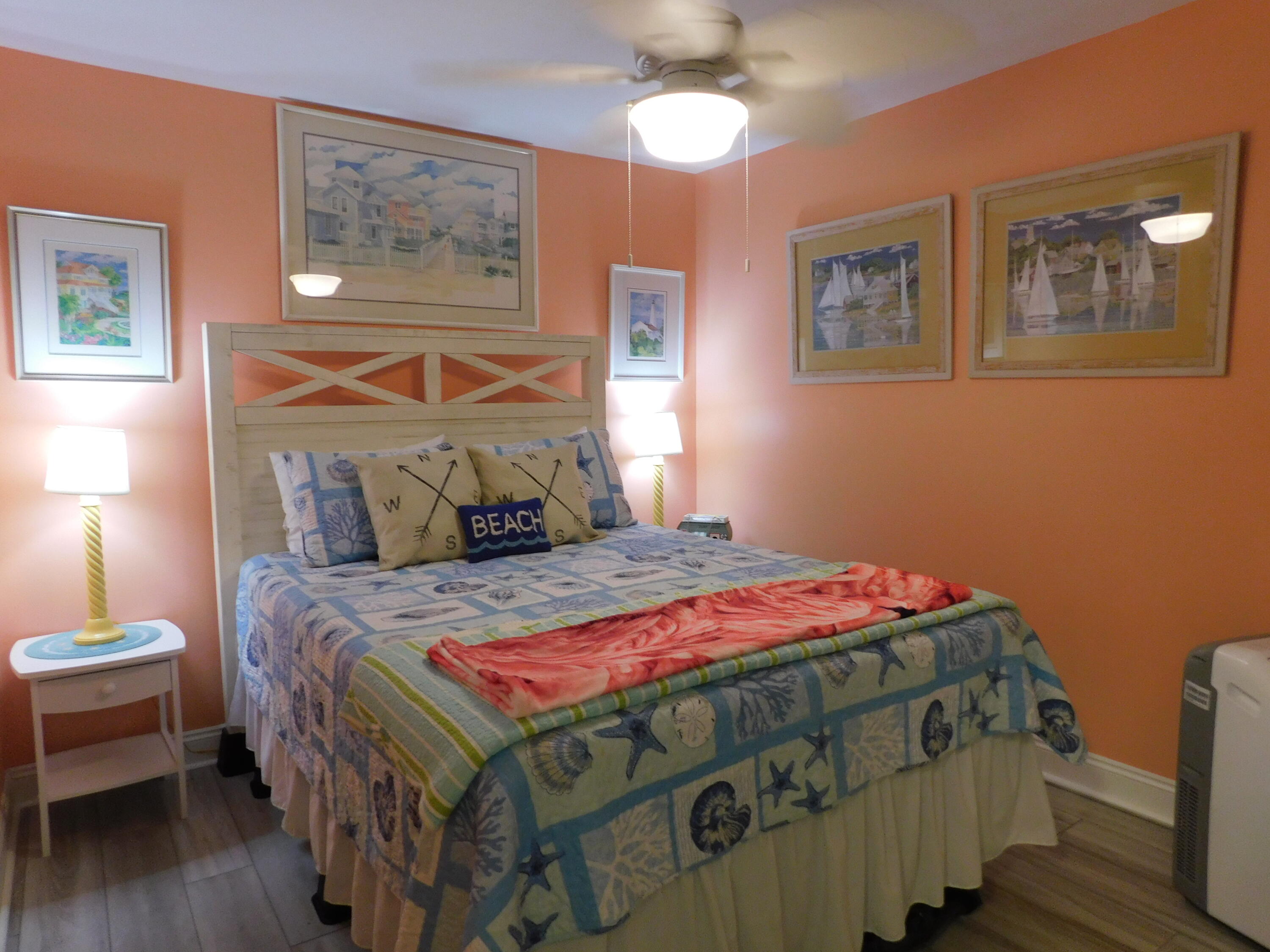 17614 Front Beach Road, Unit A38 Panama City Beach, FL 32413 - Photo 11 of 22 a bedroom with a bed a lamp on dresser and a chandelier