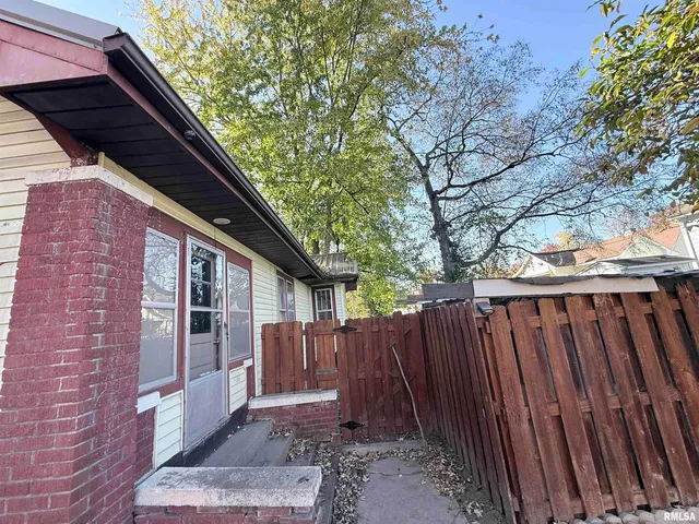 a view of backyard with wooden fence and large trees
