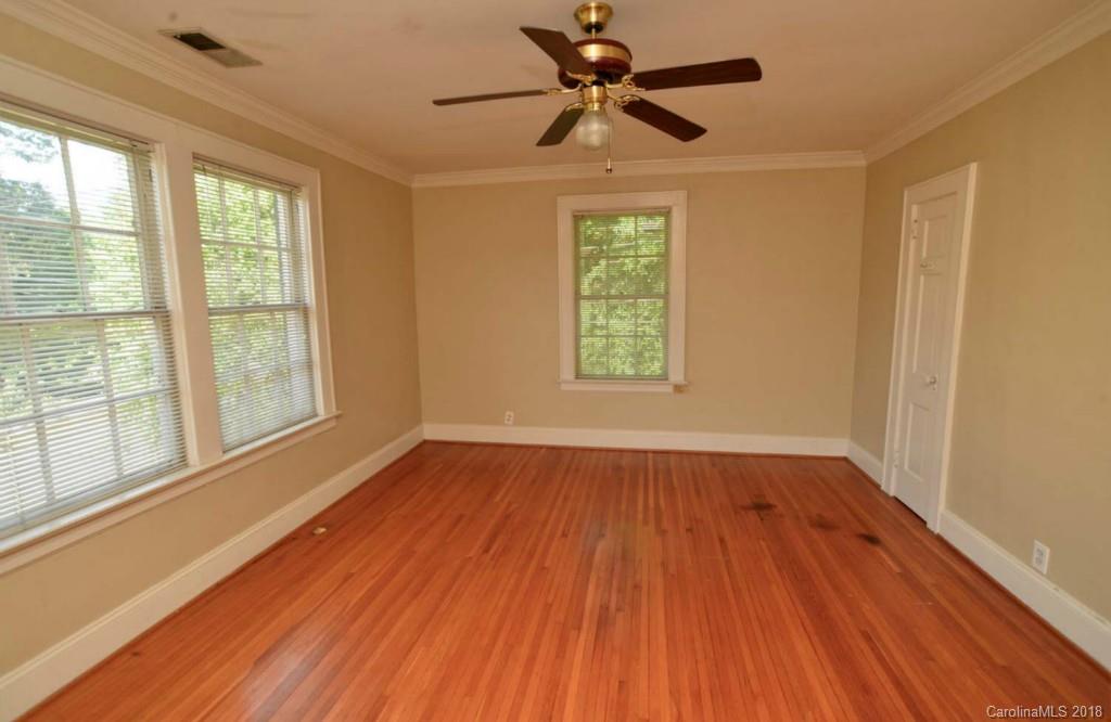 1237 Romany Road Charlotte, NC 28203 - Photo 7 of 15 an empty room with wooden floor fan and windows