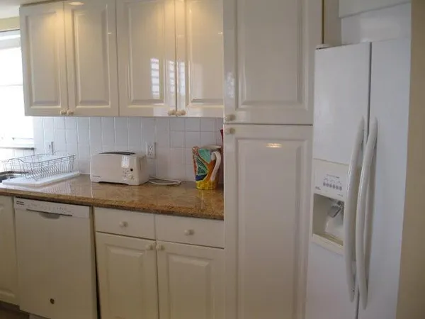 a kitchen with stainless steel appliances granite countertop a sink a window and cabinets
